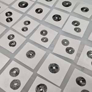 Rows of beautiful panaeolus spore prints individually cut on aluminum foil.